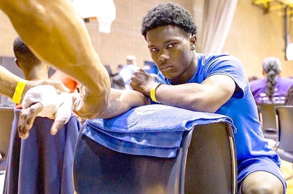 <p>Kahlil Harvey wraps Ferris Dixon’s hands before a fight at Roberto Clemente Recreation Center on June 1. Harvey is Dixon’s uncle and his trainer. Dixon won his fight by unanimous decision after three rounds. Photo courtesy of Greg Dixon.</p>