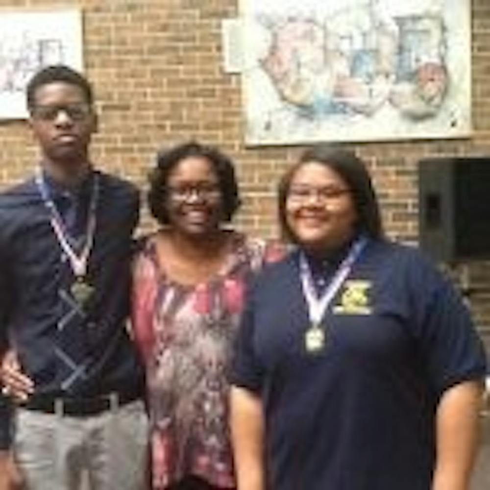 <p>Nicolas Huey, far left and Kharriane Gray far right pictured&nbsp;with their 11th grade English Teacher, Ms. Allayne Woods. Ms. Woods inspired Gray and Huey to submit their essays for the study abroad program.</p>