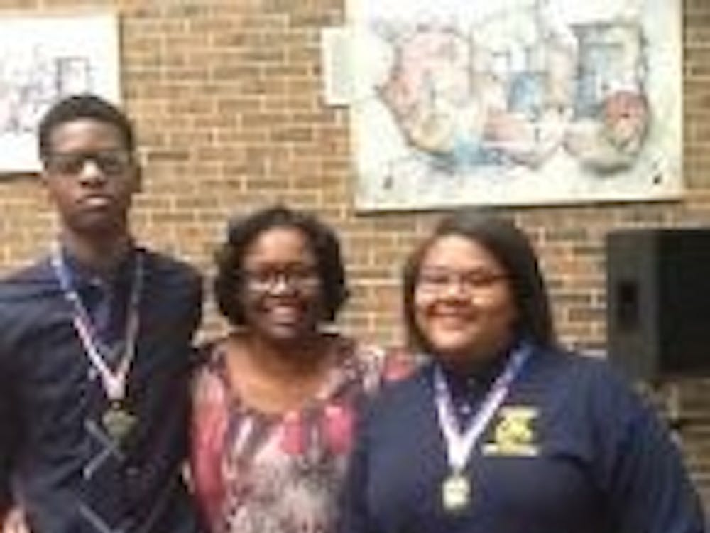 Nicolas Huey, far left and Kharriane Gray far right pictured&nbsp;with their 11th grade English Teacher, Ms. Allayne Woods. Ms. Woods inspired Gray and Huey to submit their essays for the study abroad program.