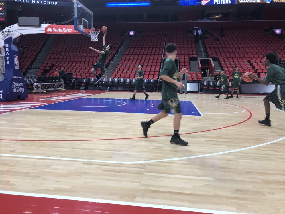 The Varsity Wolves warm up before the game at Little Caesars Arena.