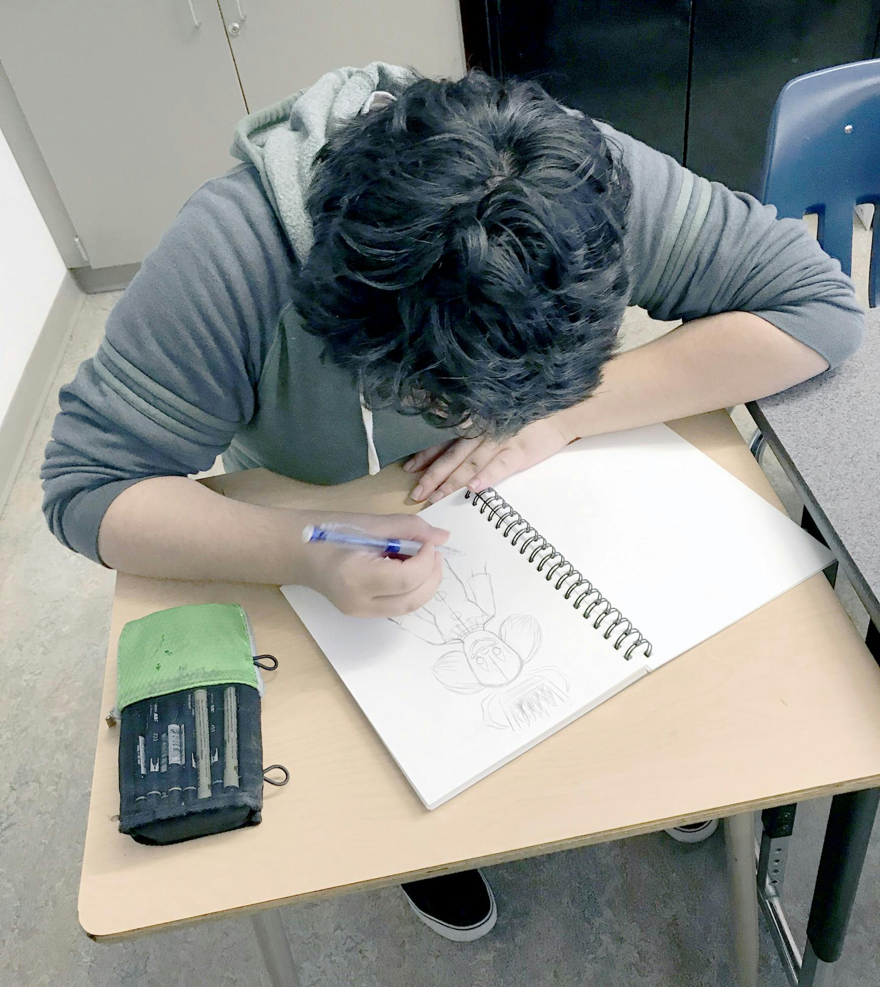 Student artist Victor Meza and an example of his art, above. Photo by Analisa Gomez.
