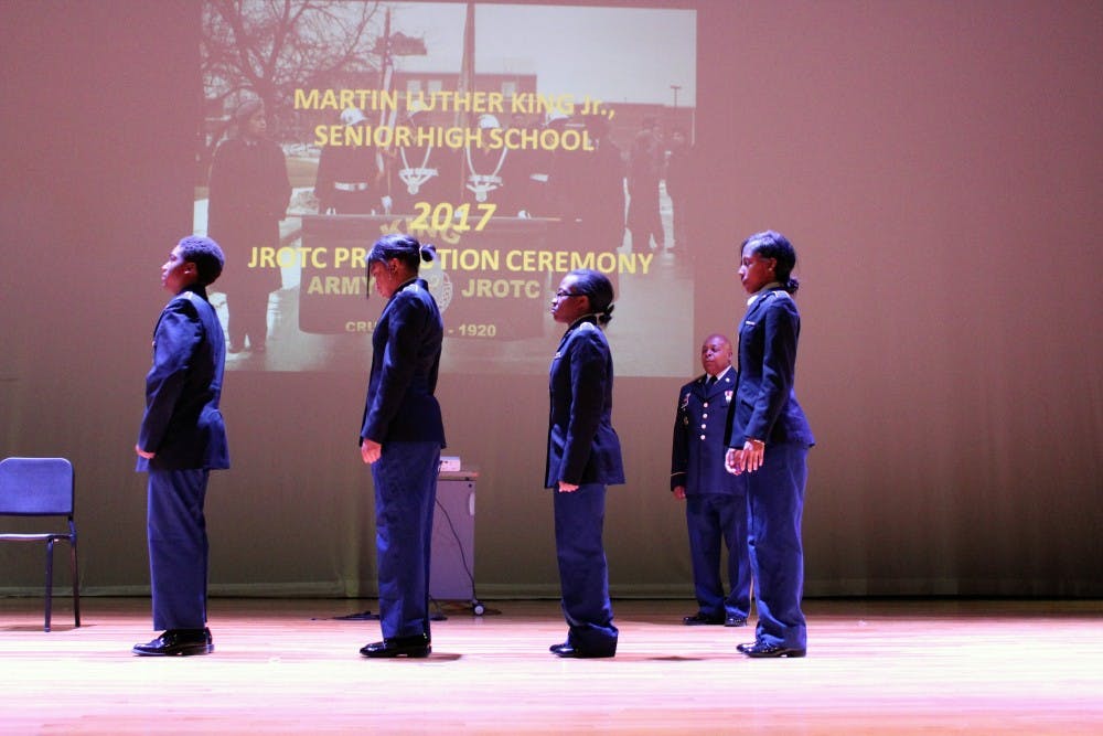 Cadets Larry Collier (freshman), Taylor Jackson (senior), Kelsey Gee (sophomore), and Darshay Burrell (sophomore) prepare to be pinned by their parents. Sergeant first class Jamille Phillips (in the back) gives the orders.