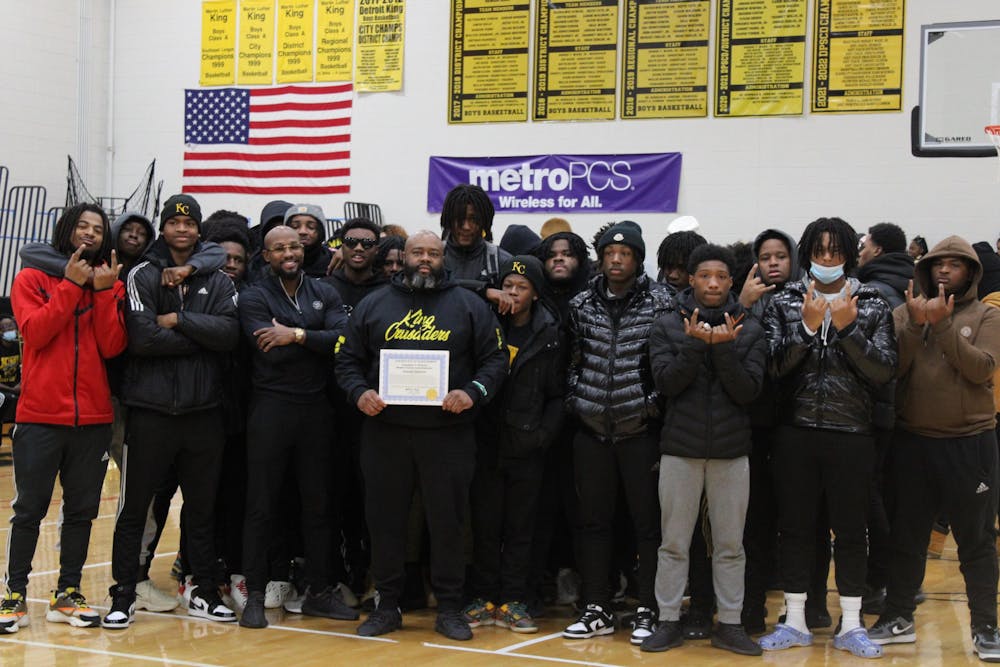 Coach Tyrone Spencer (pictured with the varsity football team) receives an award from Wayne County Commissioner Jonathan C. Kinloch for two back-to-back championships. Photo by Crusaders' Chronicle.