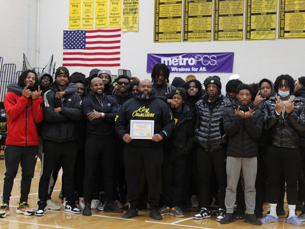 Coach Tyrone Spencer (pictured with the varsity football team) receives an award from Wayne County Commissioner Jonathan C. Kinloch for two back-to-back championships. Photo by Crusaders' Chronicle.