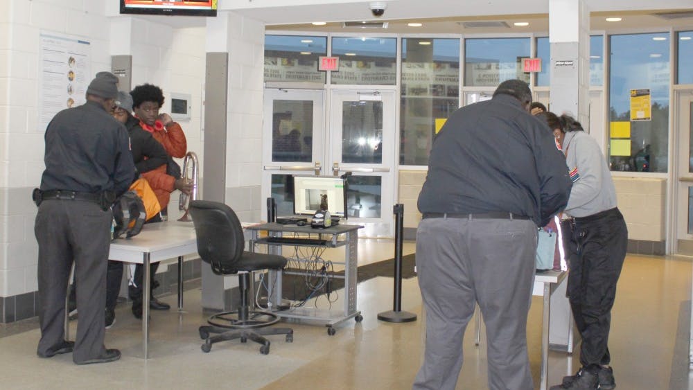 Security staff checks students and adults as they enter the building through metal detectors. This and other procedures are in place to ensure safety.