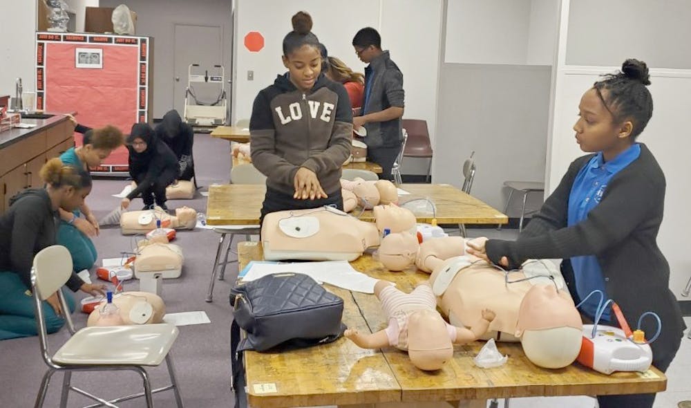 <p>Shyla Hudson and Symphony Isabelle practice CPR on mannequins along with other students. Photo courtesy of Gwendolyn Mia.</p>