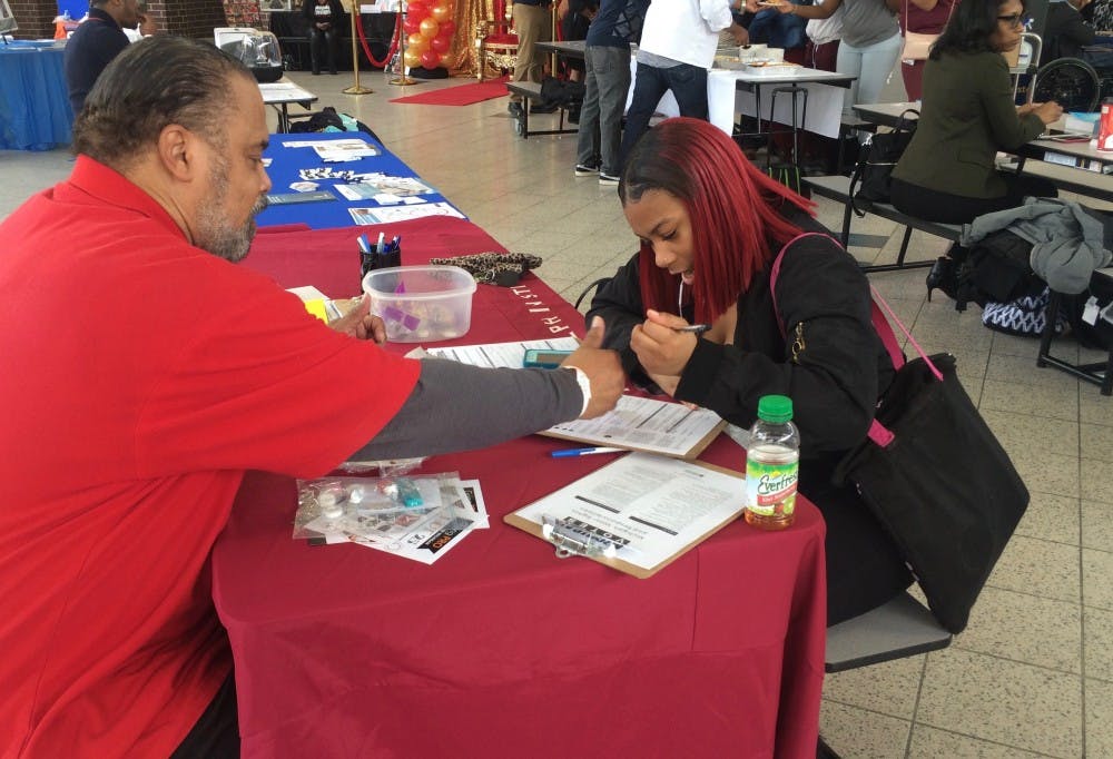 Darwin Griffin from Metro Detroit&nbsp;AFL-CIO&nbsp;helps junior Tiyatta Young fill out a voter registration form during Mumford's 2nd Annual Career Day Expo on Feb. 16.&nbsp;
