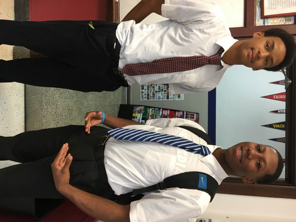 <p>Cristo Rey students&nbsp;Shaun Pruitt and Zion Stone wear their uniforms: clean-cut button downs and black slacks.</p>