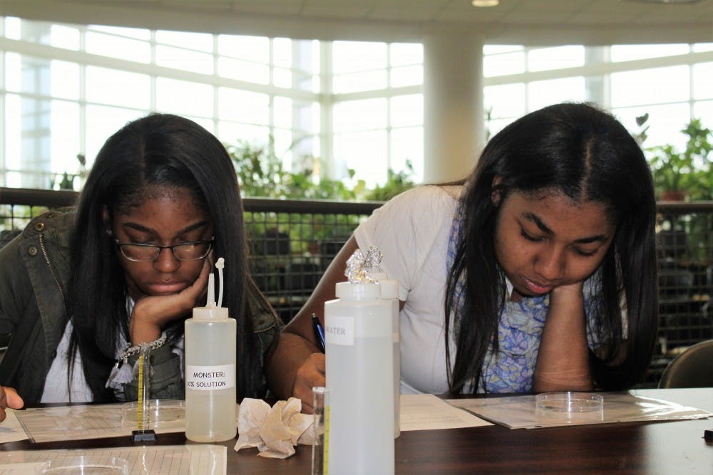<p>Seniors Ariana Foster and Camryne Stubblefield complete a DAPCEP experiment on the consequences of energy drinks.</p>