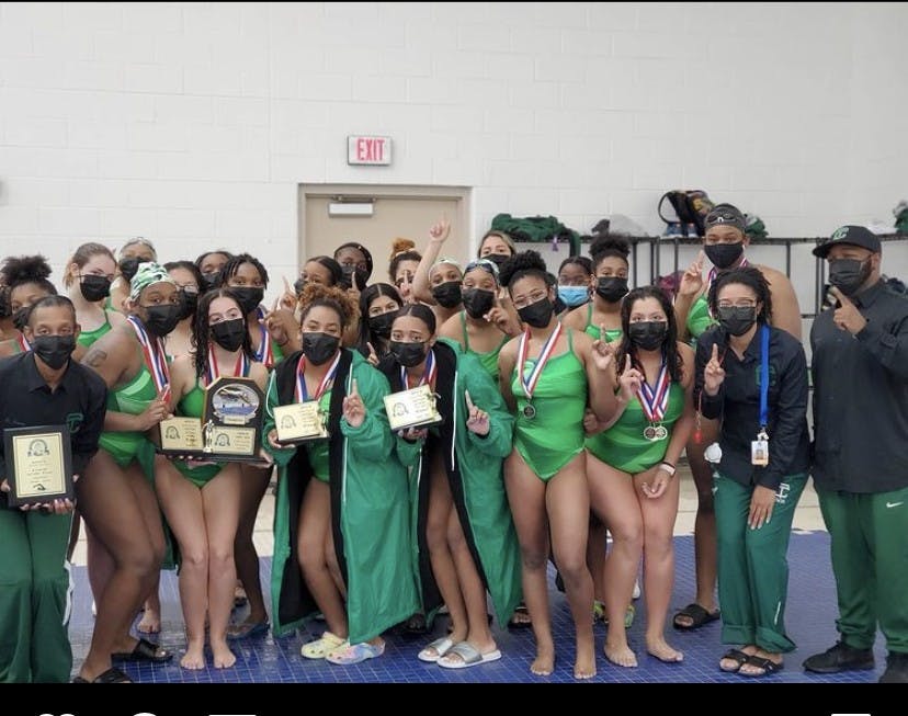 The Cass Tech girls swim team celebrates its league championship.