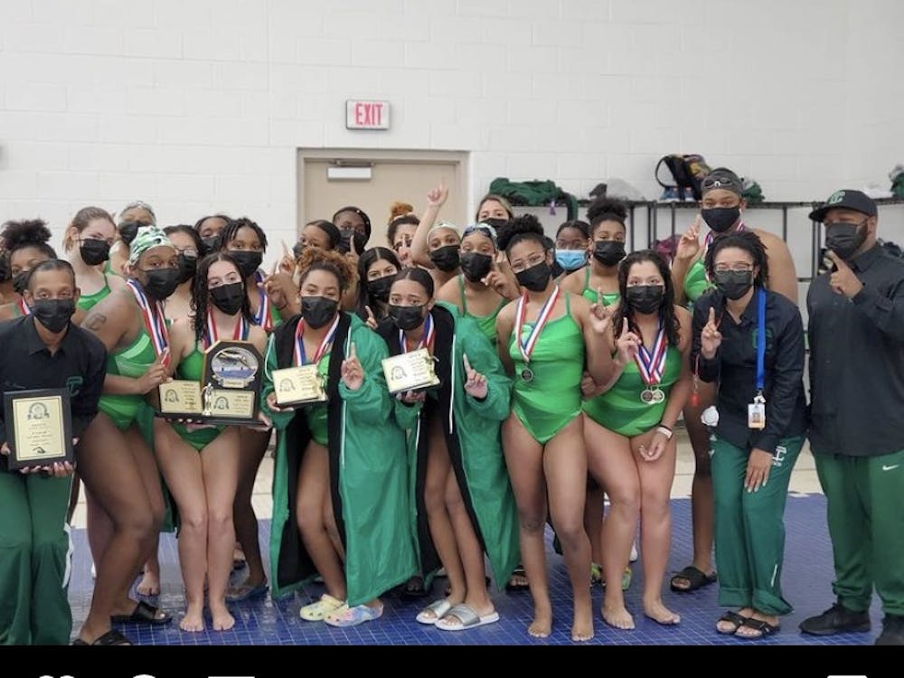 The Cass Tech girls swim team celebrates its league championship.