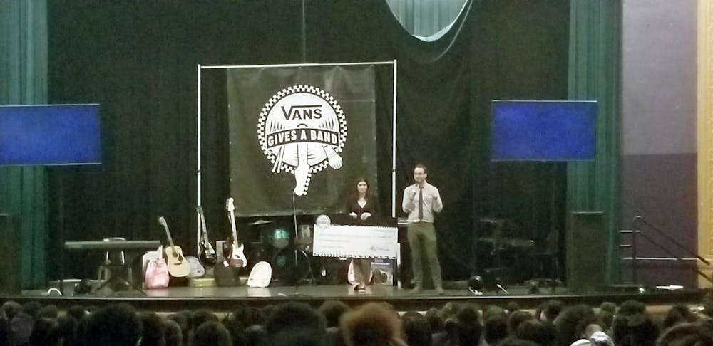 <p>Benjamin Piper accepts check and instruments from the Vans after receiving a grant.</p>