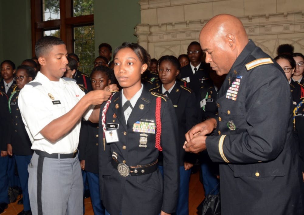 <p>Core Commander Lawerence Shepherd (right) honors Lauryen Smith alongside Colonel George Pettigrew (left), Director of Army Instruction in Detroit Public Schools</p>