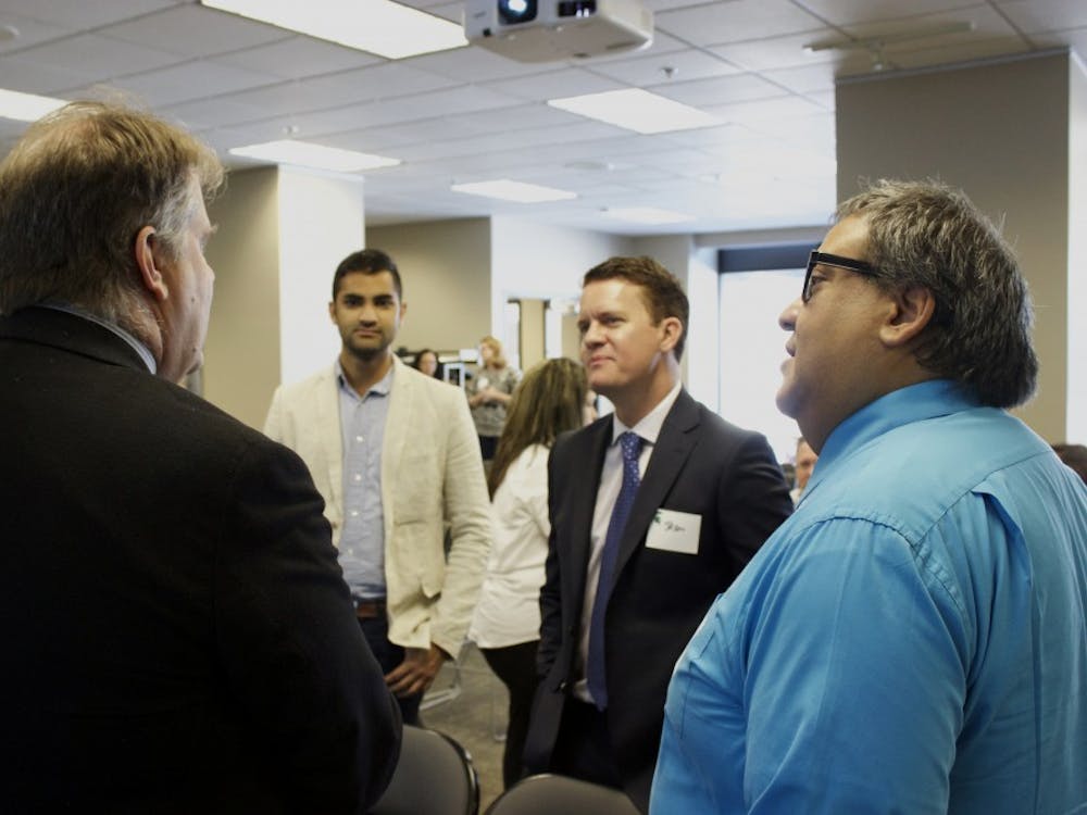 Michigan State University School of Journalism Editor in Residence Joe Grimm, left, talks with Jason Stein, publisher of Automotive News and other Crain staff members.