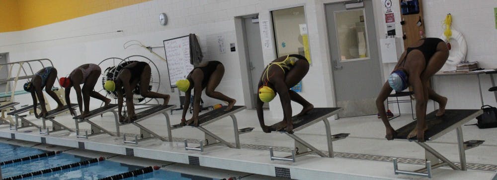 Girls’ swim team prepare before the city championship swim meet.