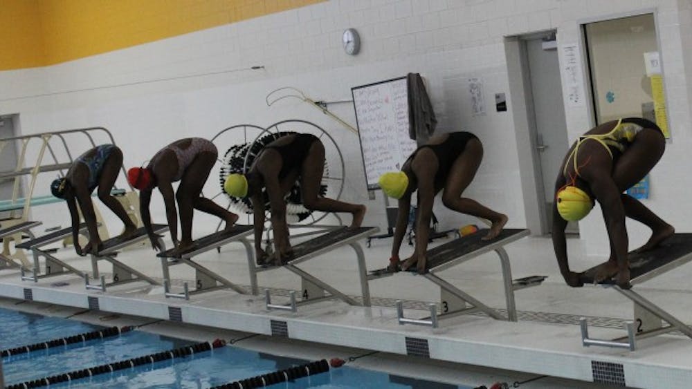 Girls’ swim team prepare before the city championship swim meet.