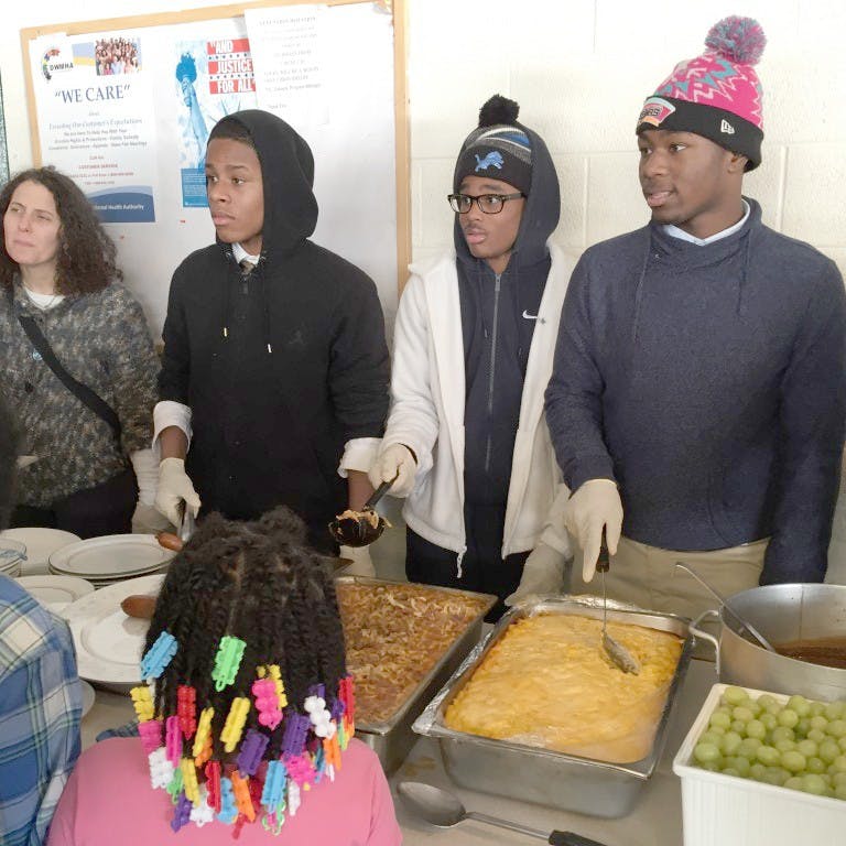 Loyola students serve the meals they helped prepare at Cass Community Services at Forgotten Harvest.
