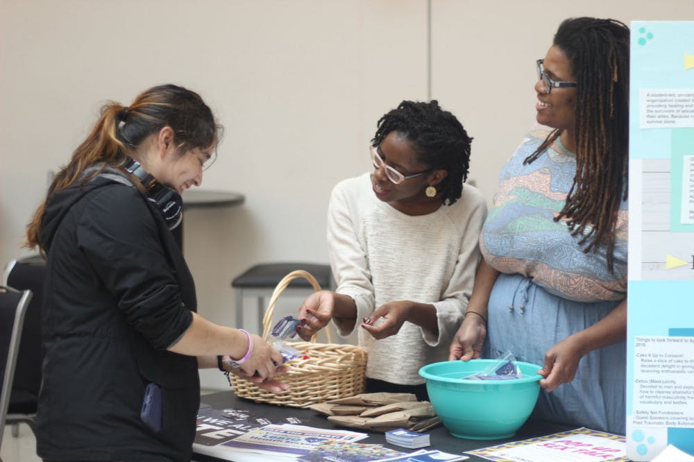 <p>Safety Net member Nikkino Wesson and Patricia Thomas let U of M senior Barbarita Vega pick condoms out of a basket. The group handed out condoms to anyone who talked to them about college sex issues.</p>