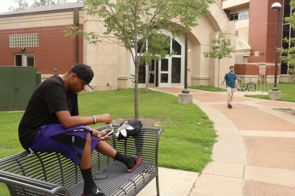 <p>A U of M student sits outside of the Living Learning Complex. Previously the all-honor's dorm, the LLC was made an all freshman dorm in the fall.</p>