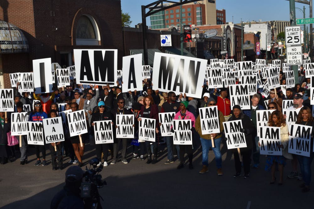 <p>People participating in the Sanitation Strike photo re-enactment raise their signs in the air for a drone to photograph. The daughter of Ernest Withers, who took the original iconic photo, took this shot of the re-enactment.</p>