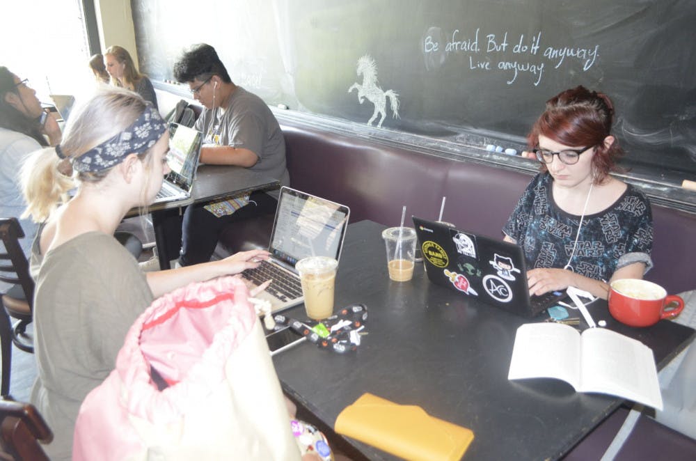 <p>Savannah Frizzle and Alissa Diggs work on their laptops at Avenue Coffee on Echles Street near campus. Avenue is one of the more popular study spots for U of M students.</p>