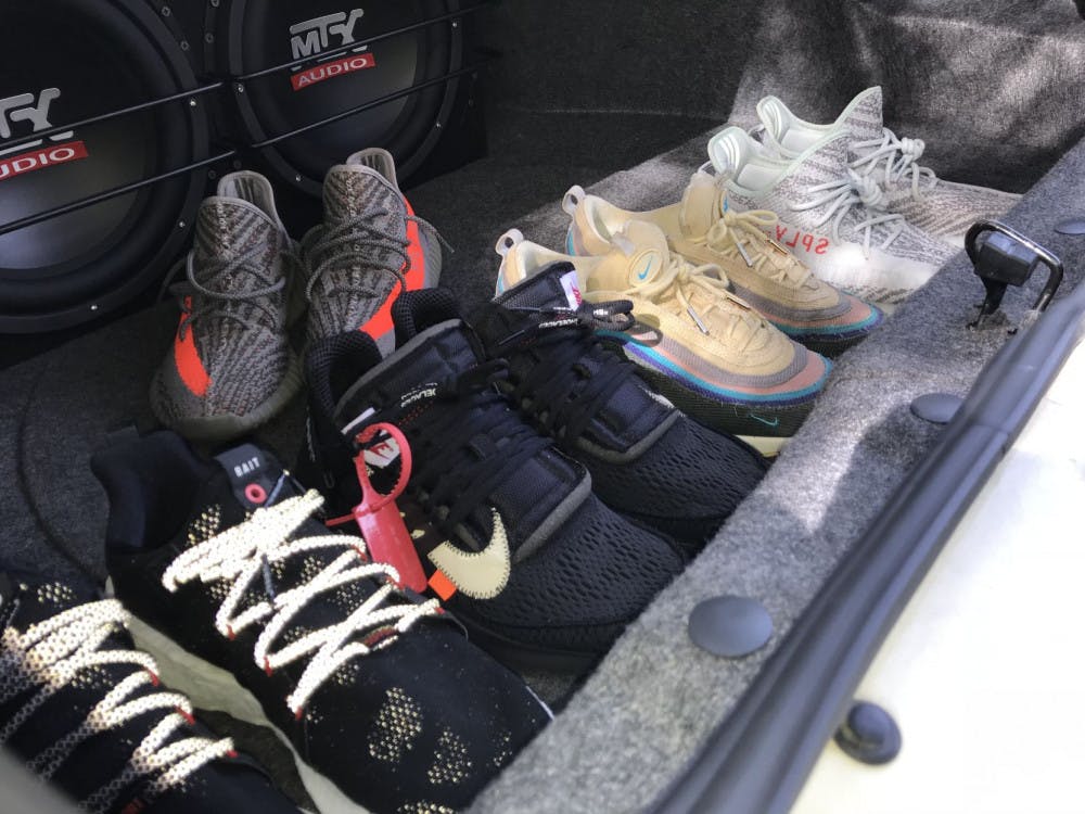 <p class="p1"><span class="s1">Thomas Fulcher shows off exclusive sneakers from his collection in the trunk of his car. Many of his shoes, including the Yeezy Boost 350 v2 “Blue Tints” (far right) and the Nike Off-White black Prestos (second from left) were released in limited quantities and sold out quickly.</span></p>