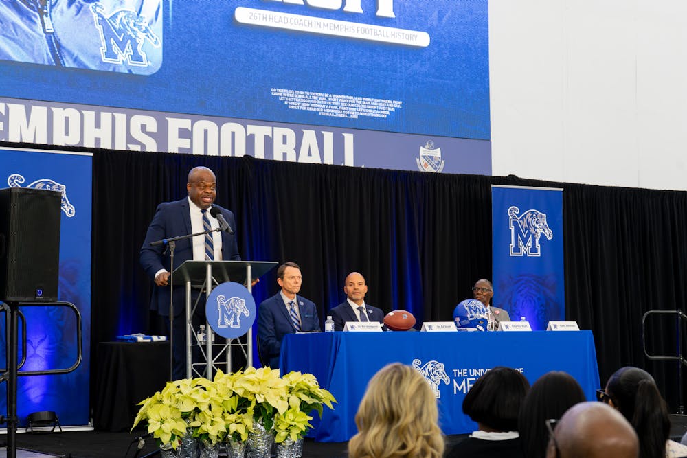 Memphis' new head football coach, Charles Huff, speaks at his introductory press conference as University President Bill Hardgrave and Athletic Director Ed Scott look on.