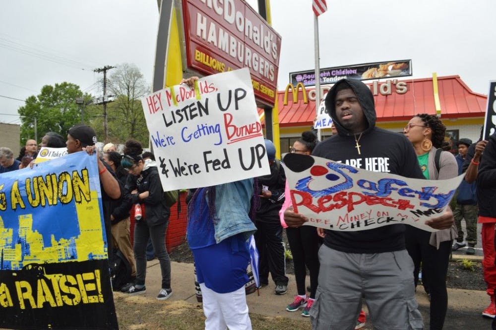 <p>Demonstrators marched from the University of Memphis to McDonald's on Highland in a national&nbsp;protest for a living wage of $15 a hour. Protesters march on the sidewalk on Southern with the&nbsp;banner “Memphis needs a raise.” Photo by Sarah Fultz</p>