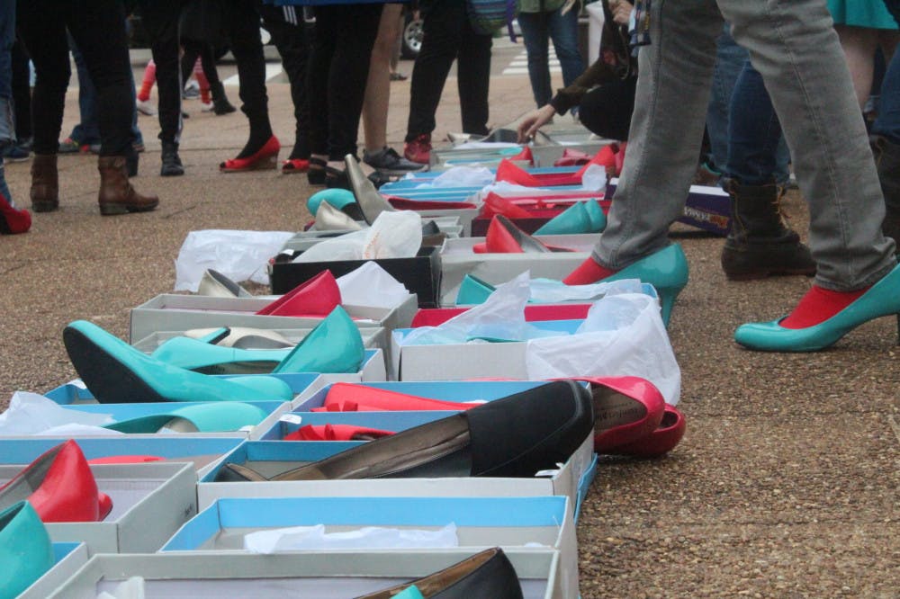 <p>Students try on shoes to prepare for Walk a Mile in Her Shoes. Students could chose any color they want to walk in for the event.</p>