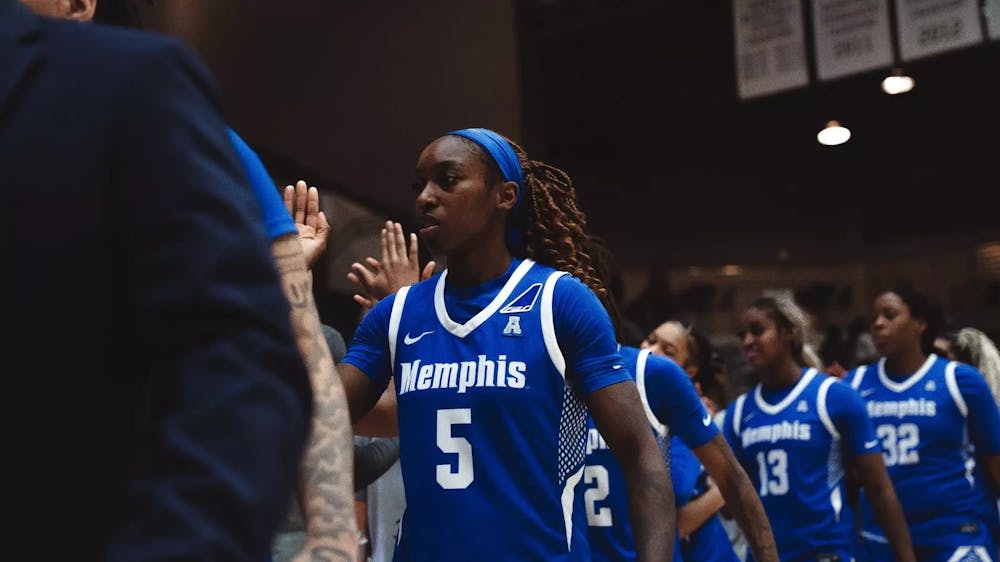 Memphis guard Chaé Harris goes through the high-five line after hitting the game-winning shot in the Tigers' road victory at Little Rock Friday night.