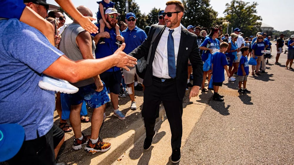 Memphis head coach Ryan Silverfield high fives fans at the Tiger Walk.