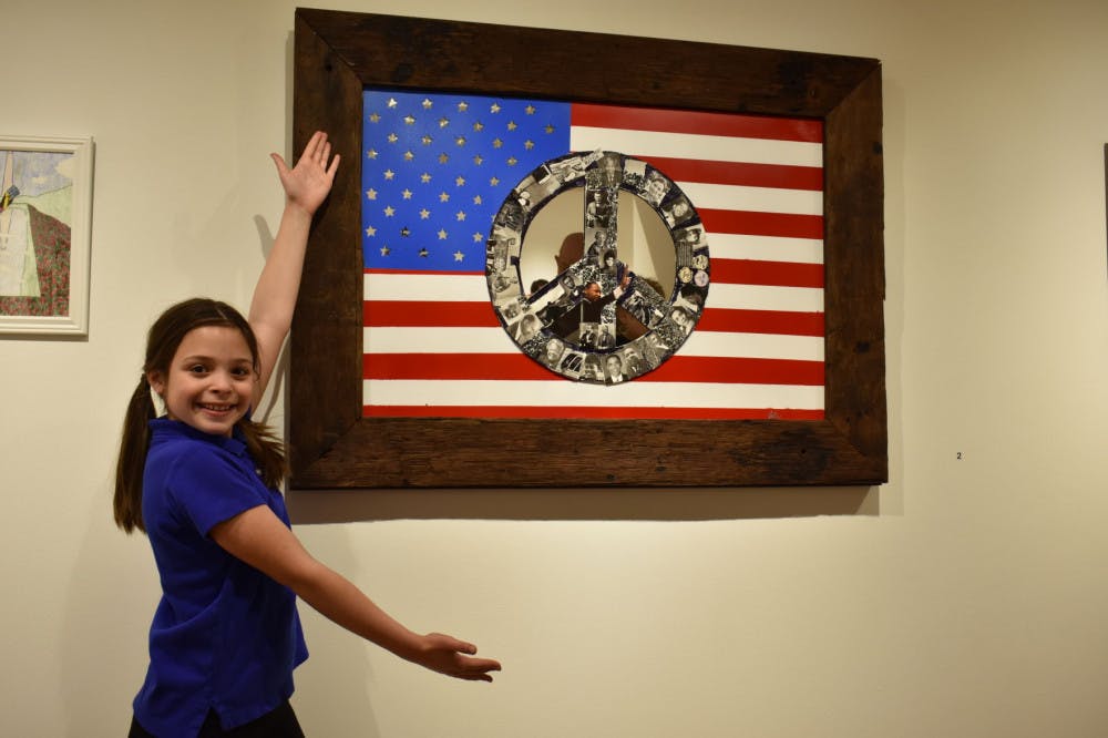 <p class="p1"><span class="s1">Julie Kyle, a 10-year-old Campus School student, unveiled her piece, “A Star for Life,” at the 12th Annual Art Education Alumni Juried Exhibition. Using images of Civil Rights figures and a mirror, Kyle said she hopes people will reflect and ask themselves, “What can I do to make a difference for those in need?”</span></p>