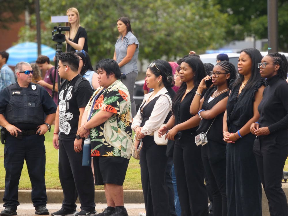 <p>Student protestors stand shoulder to shoulder wearing black to protest the firing of the Office of Multicultural Affairs staff.</p>