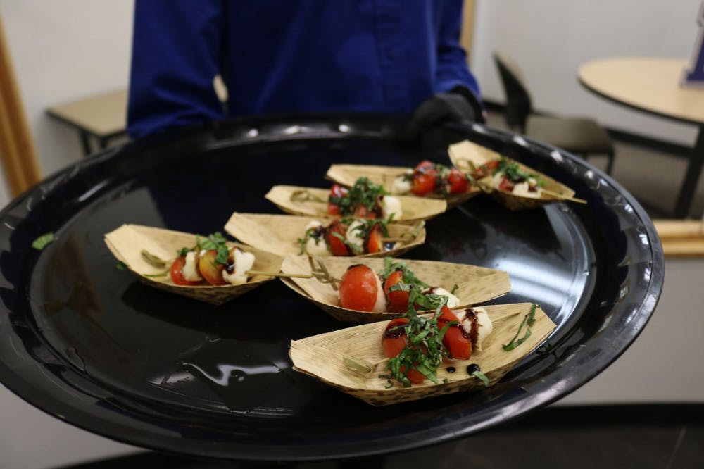 <p>A server brings a dish out for guests to try. Attendees were treated to various dishes from barbeque to ice cream.&nbsp;</p>