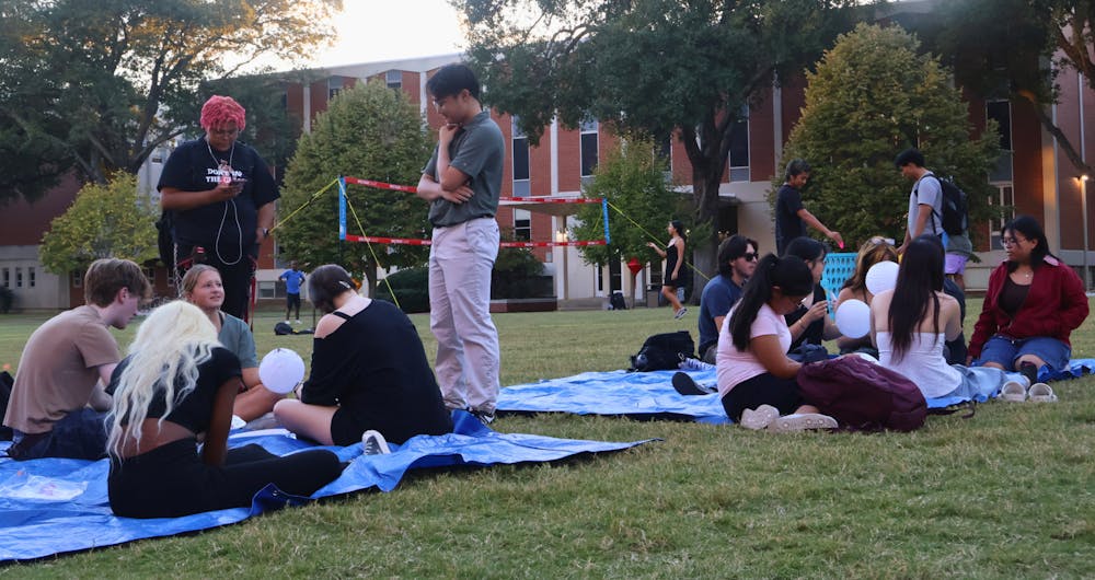 Students enjoy the company of friends and the fresh air at the Vietnamese Student Association autumn festival Wednesday evening.
