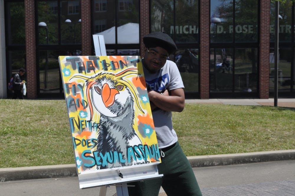 <p>Jarvis Howard, 24, paints a live painting during the Healthy Relationships Fair. Howard said he wanted to stay with the theme of the fair, so he drew a penguin since they don't fly and neither does sexual assault.&nbsp;</p>
