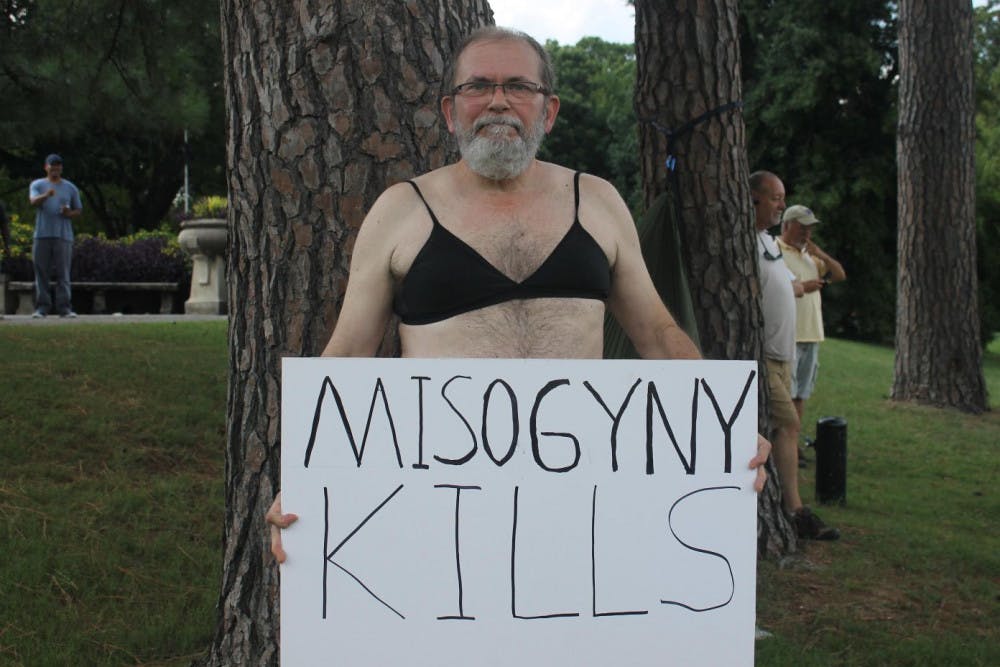 <p>Buss McCormick, 61 wears his late wife’s Victoria’s Secret bra while protesting with a handmade sign. “Some friends of my adult daughters shared the event on Facebook and I decided to come,” McCormick said. “I’m just trying to promote change in our conservative city.”</p>