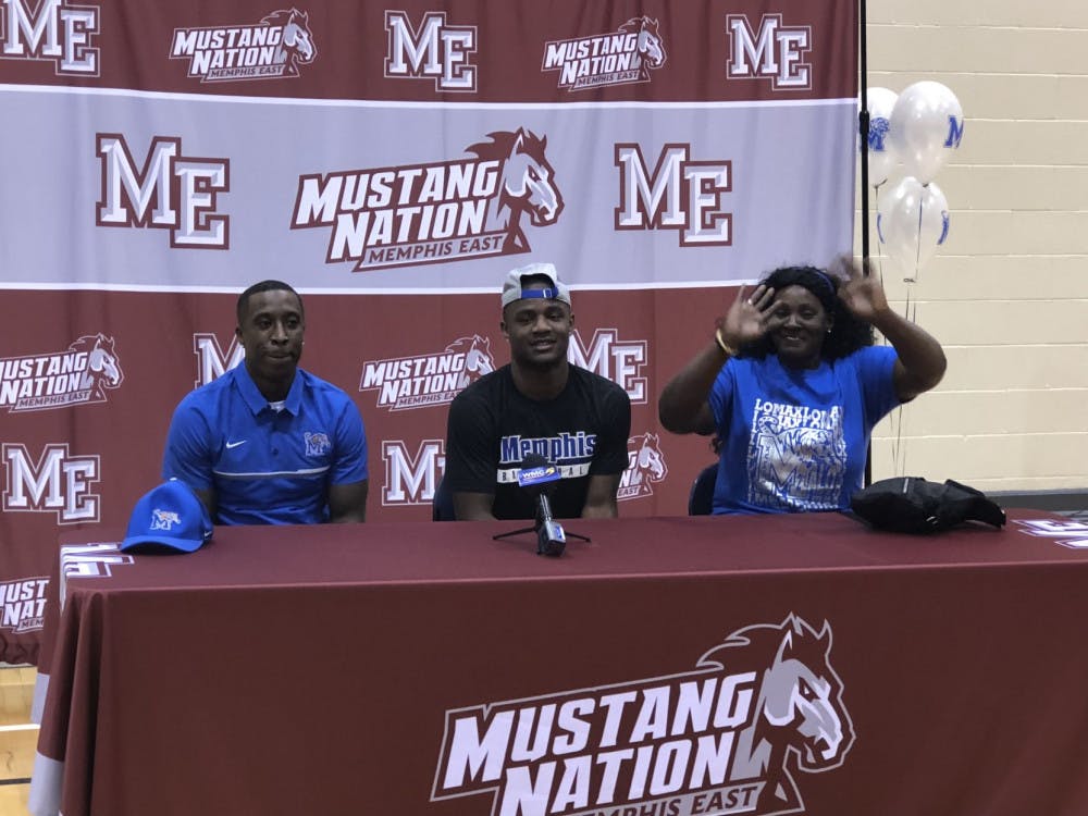 <p>Alex Lomax, middle, sits with his parents on each side of him for his signing event. Lomax played under new Memphis coach Penny Hardaway at Memphis East High School.</p>