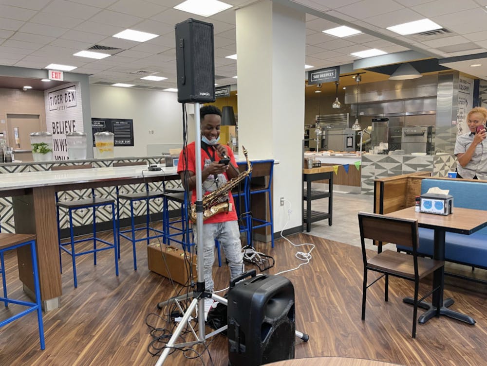 <p dir="ltr"><span>Jamari scrolling through playlist finding the next song to play. The musician played modern songs on his saxophone throughout the event.</span></p>