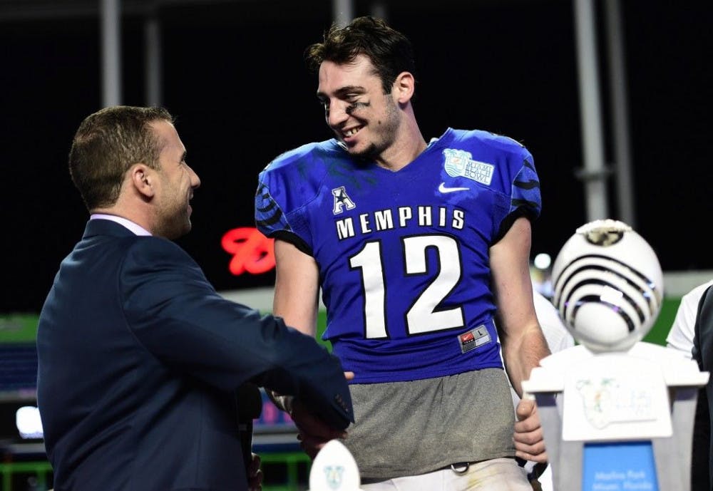 <p>Miami Beach Bowl Executive Director Carlos Padilla congratulating Memphis quarterback Paxton Lynch on being named the game’s Most Valuable Player in the Miami Beach Bowl. Lynch had seven total touchdowns in the victory. Photo by Ben Solomon.</p>