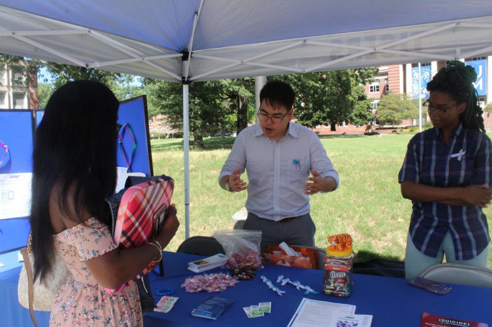 <p class="p1"><span class="s1">A student talks with Jason Wong, middle, and Aria Amos, right, employees from the Couseling Center and the Department of Student Counseling and Health Services. Their booth was set up to promote education about suicide.</span></p>