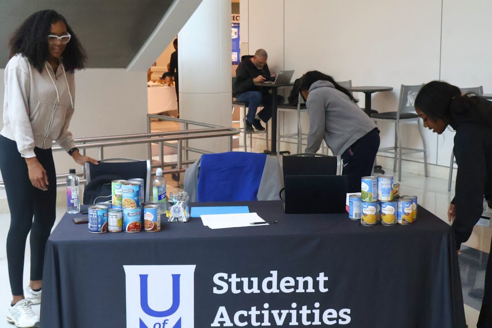 <p>Members of the Student Activities Council arrange donated goods during the annual Roar for More Canned Food Drive in the University Center on Wednesday.</p>