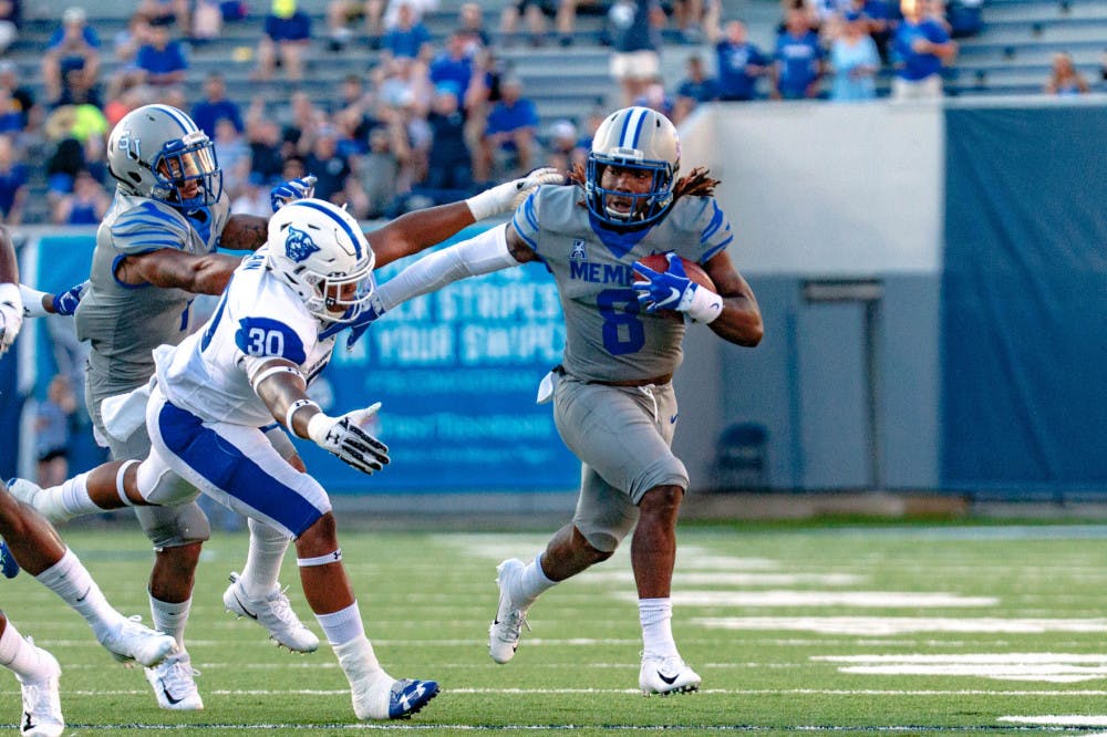 <p>Darrell Henderson pushes off on a defender as he rushes towards the end zone. Henderson had more than 200 yards rushing against Georgia State.</p>