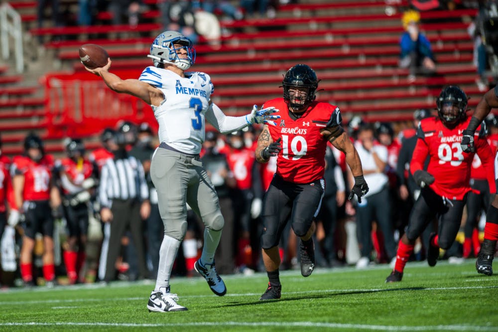 <p>Memphis quarterback Brady White throws downfield while avoiding a Cincinnati defender. The Tigers ended the game with a hefty 49-10 loss.&nbsp;</p>