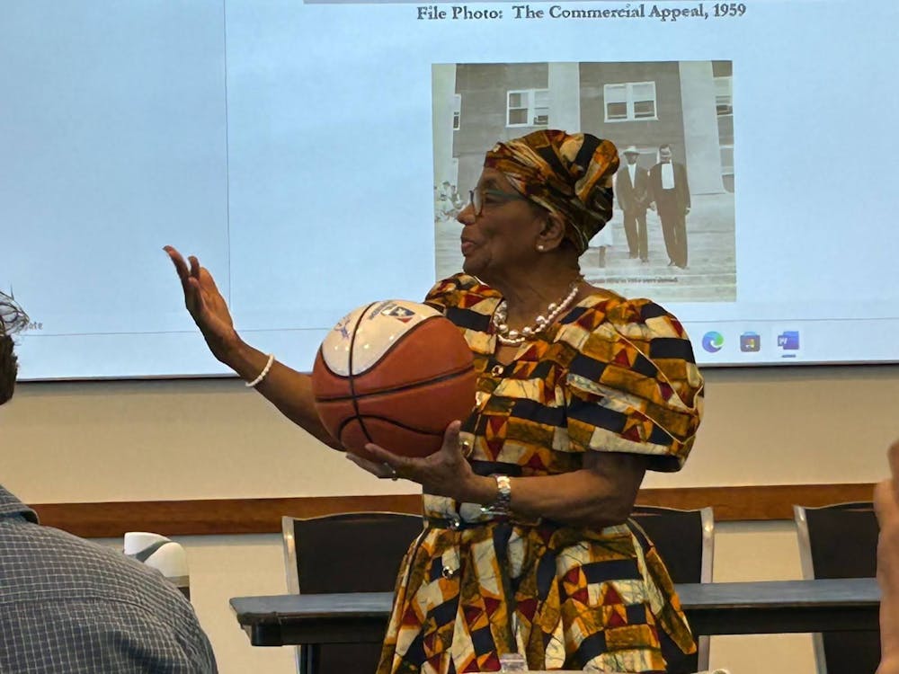 <p>Bertha Rogers Looney, a member of the Memphis State Eight, receiving a signed basketball from the Tigers basketball team.<br/><br/><br/><br/></p>