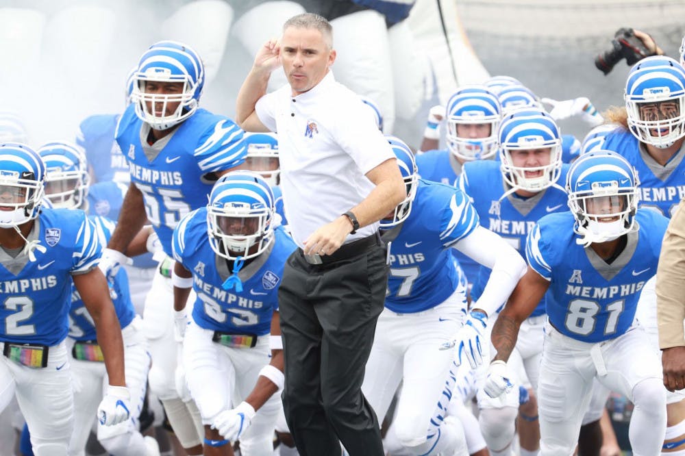<p>Memphis Tigers head coach Mike Norvell runs out of the tunnel with his team.&nbsp;</p>