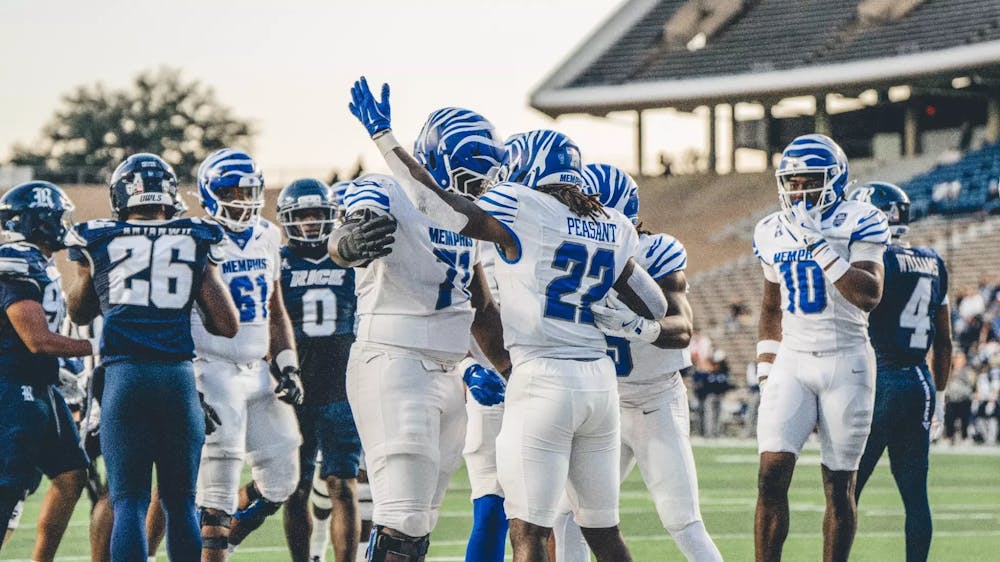 Memphis running back Frank Peasant celebrates one of his three touchdown runs with his offensive line in the Tigers' 38-14 victory at Rice Friday night.