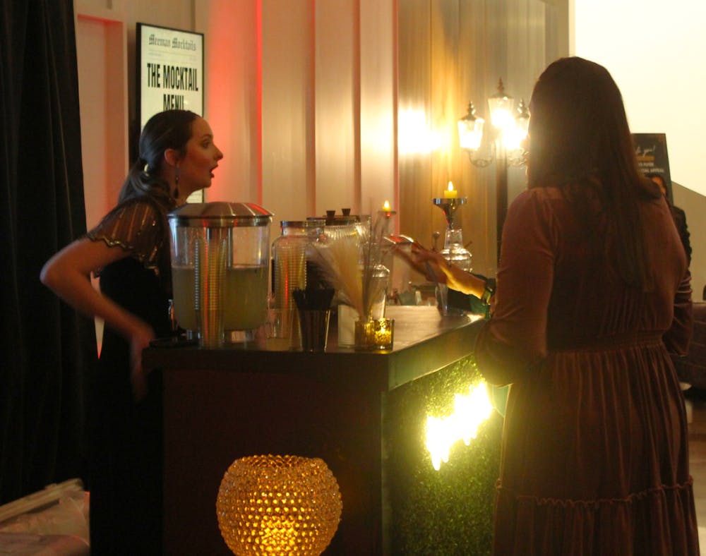 <p>Student Meg McVay serves handcrafted mocktails to guests at the Meeman Mocktails event in the Scheidt on Wednesday evening.</p>