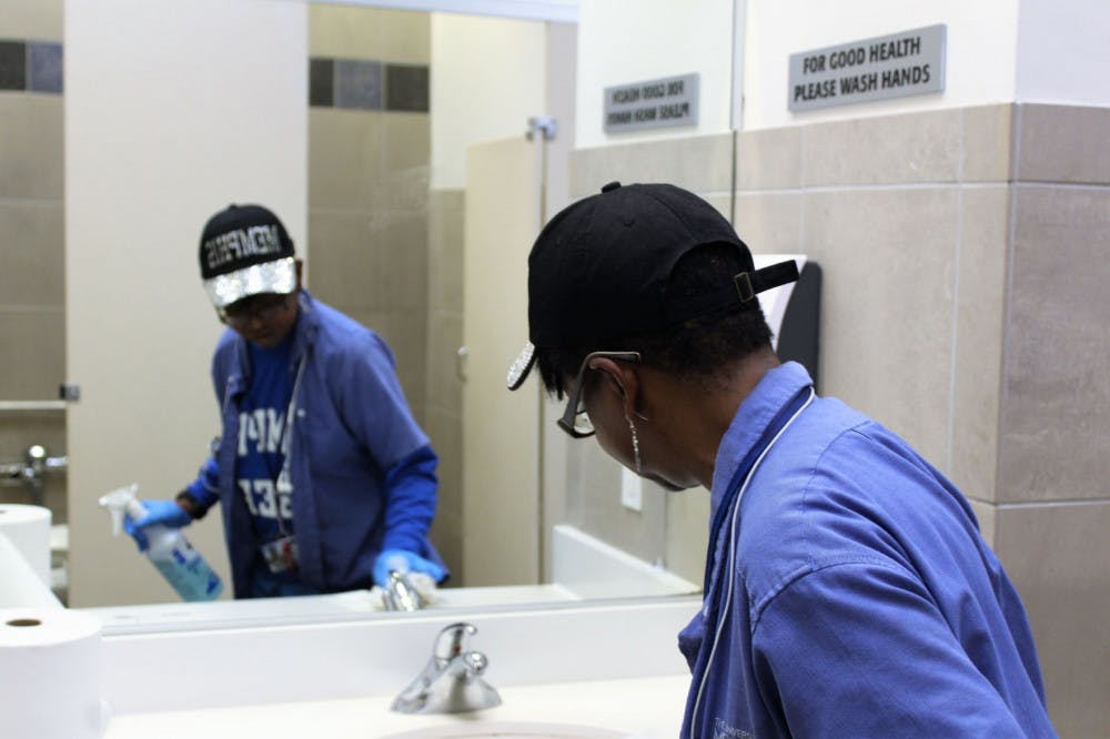 <p>Sharon Gale is wiping off the sink and the mirror in the women's bathroom in the University Center. One of Gales job is to go around to all of the bathrooms on the first floor of the UC and clean them from top to bottom.&nbsp;</p>