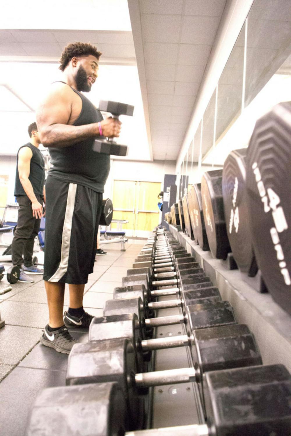 <p>A student lifts weights at the current U of M recreation center. President M. David Rudd announced there would be an 18 month delay on construction of a new rec center, which was supposed to start this semester.&nbsp;</p>